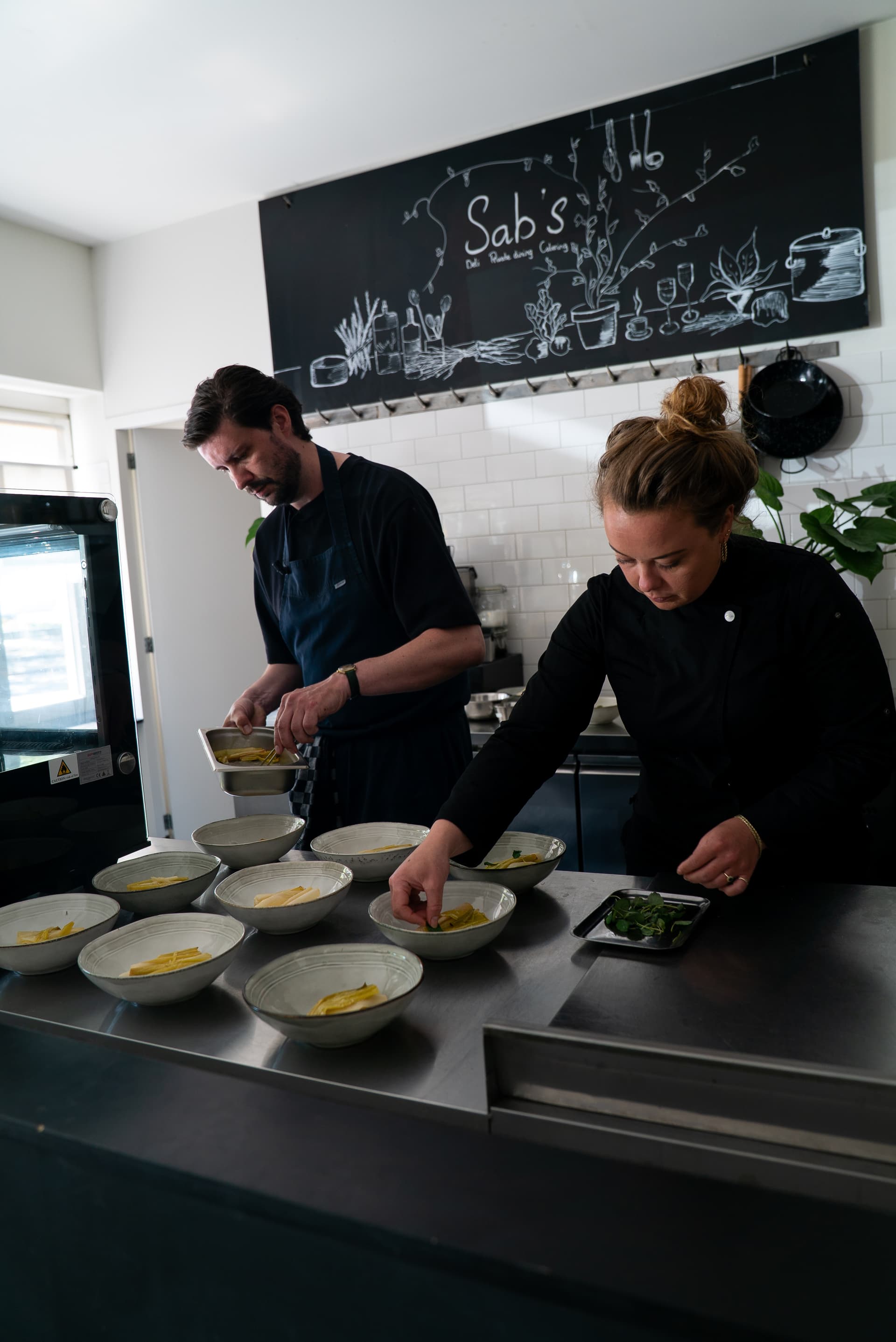 Twee chefs werken in de keuken van Sabs Deli